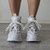 Vista posterior de zapatillas Mita en color blanco, con cordones sueltos y detalle de diseño en la parte superior.