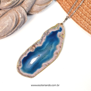 Colar feito com chapa de Ágata Azul, apresentando tonalidades de azul e rosa, pendurado em uma corrente prateada.