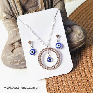 Conjunto de brinco e colar folheado a prata com design de olho grego, exibindo detalhes em azul e branco.