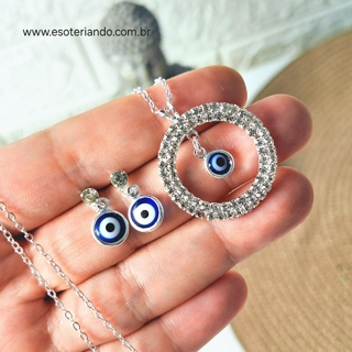 Conjunto de brinco e colar folheado a prata com design de olho grego, exibindo detalhes em azul e branco.
