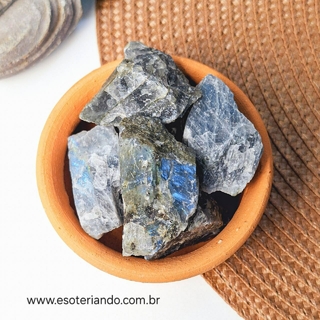 Pedras brutas de labradorita em um vaso de barro, destacando suas cores místicas.