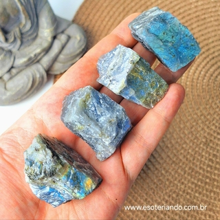 Pedras brutas de labradorita em um vaso de barro, destacando suas cores místicas.