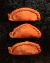 Empanadas freezadas rellenas de Pastrón Casero,  con chucrut y queso suizo, listas para hornear, receta original por Asado Feroz. La masa es casera con harina orgánica, pigmentada color naranja de forma natural.