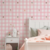 Papel de parede infantil com padrão de xadrez rosa com detalhes de fadas fofas.