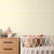 Papel de parede infantil em padrão xadrez vichy amarelo em um quarto com móveis neutros.