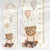 Régua medidora de altura adesiva com design de fadas, incluindo um urso sentado com balões, estrelas e um arco-íris.