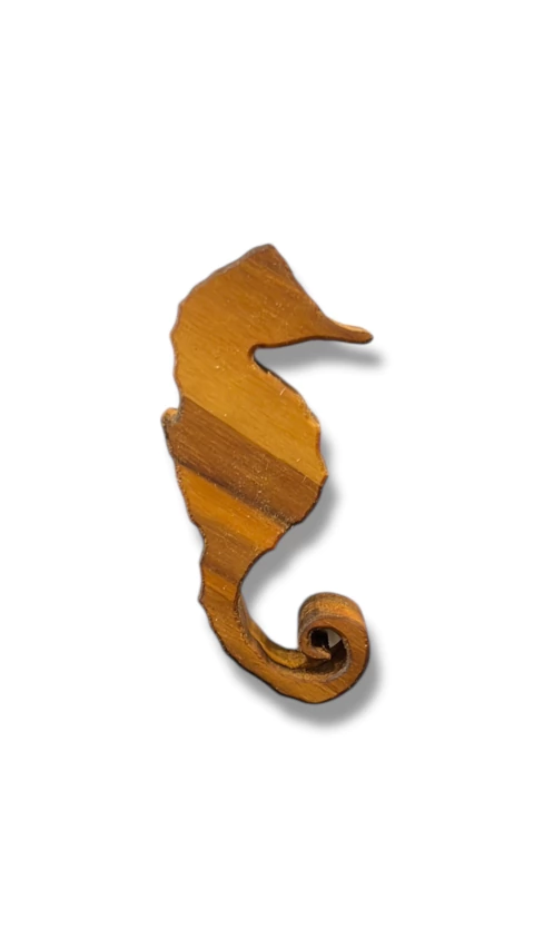Imã de madeira em formato de cavalo-marinho, representando Logun Edé, com aproximadamente 10cm de altura.