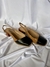 Scarpin slingback com bico preto e laterais caramelo claro. Salto externo de madeira com altura de 5cm