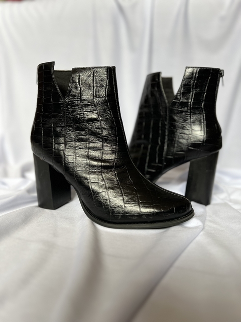 Bota preta croco de salto feminina com salto da mesma cor de 9cm, detalhe lateral com abertura e acabamentos minimalistas