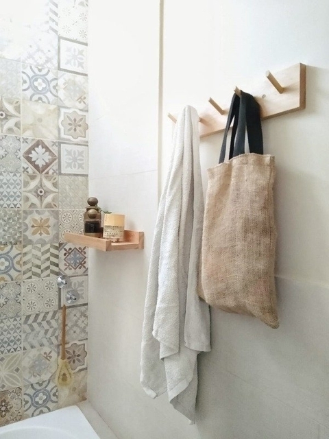 Perchero Arrayán Kiri con toallas y bolsa de yute en un baño decorado con azulejos coloridos.