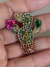 Broche dourado cacto colorido na internet