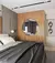 Espelho Moon com moldura redonda instalado em painel de madeira decorativo em quarto moderno, com cama de casal e luminária pendente ao lado.