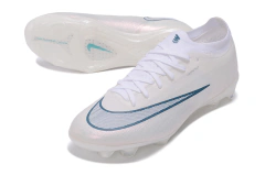 Chuteira de campo branca Nike Air Zoom Mercurial Vapor 17 Elite FG com detalhe em azul escuro e solado com travas para gramado