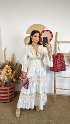 Modelo usando um vestido indiano longo Eleonora, com detalhes em renda e franjas, segurando uma bolsa colorida.