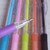 Lapiseira 0,5mm Poly Teen da Faber-Castell em destaque, com várias opções coloridas ao fundo.