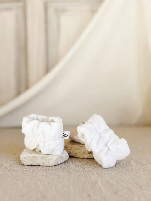 Muñequeras de toalla para skincare, colocadas sobre muñecas, absorben el agua.