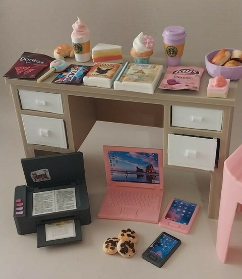 Escritorio para muñecas Barbie con accesorios como computadora portátil, impresora y comida en miniatura.
