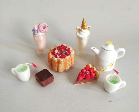 Conjunto de miniaturas de pastelería que incluye torta, postres y una tetera.