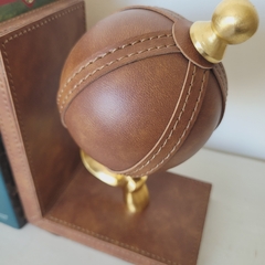Prensalibros de cuero y metal con forma de pelota de rugby.