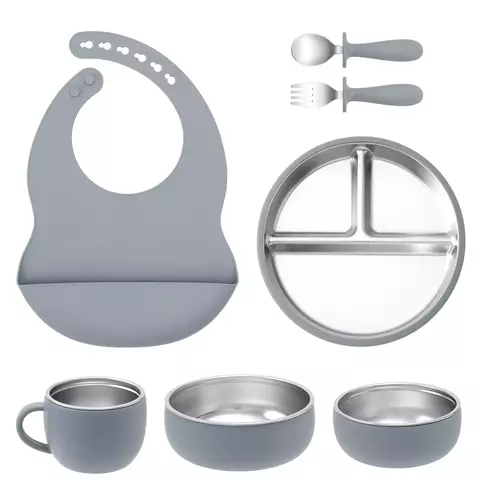 Kit alimentação infantil com 7 peças em silicone cinza e aço inoxidável, incluindo babador, prato com divisórias, talheres, copo com alça e duas tigelas
