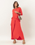 Mulher vestindo um conjunto vermelho composto por blusa de manga longa e saia longa, com sandálias de plataforma e bolsa transversal.