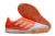 Chuteira futsal Adidas Competition top IC com design laranja e detalhes em branco, vista de cima e sola.