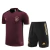 Conjunto de treino da seleção alemã, composto por uma camisa vinho com detalhes pretos e dourados e shorts pretos com detalhes dourados, ideal para atividades esportivas.