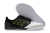 Chuteira de futsal Adidas, modelo Competition top IC, com design preto e detalhes em amarelo, mostrando a parte superior e a sola.