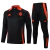 Conjunto de treinamento Adidas na cor preta com detalhes em laranja, incluindo uma jaqueta de manga longa e calças.