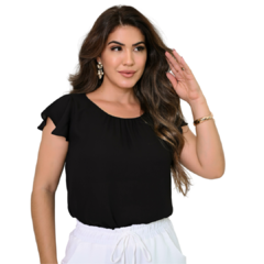Mulher com blusa preta e mangas curtas, posando e sorrindo.