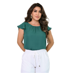 Modelo usando blusa verde com mangas levemente bufantes e calça branca.