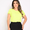 Mulher posando com uma blusa amarelo neon e saia preta, com cabelo solto e sorriso.
