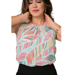 Mulher vestindo blusa estampada com padrão de folhas em cores suaves, posando com as mãos no pescoço.