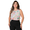 Mulher posando com uma blusa de estampas coloridas e calças pretas.