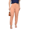 Mulher usando calça rosa claro e blusa azul escura, segurando uma bolsa marrom.