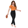 Mulher caminhando com uma blusa laranja e calças pretas, segurando uma bolsa marrom.