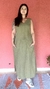 Blusa verde musgo, com um design simples, em um fundo rosa. A blusa possui um corte solto e dois bolsos frontais.