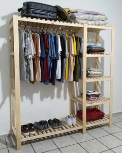 Roupeiro em madeira maciça com roupas penduradas, sapatos organizados na parte inferior e malas em cima, ideal para quartos e utilidades.