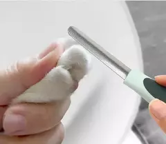Uma mão segurando a pata de um animal enquanto utiliza uma lixa para unhas.