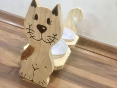 Comedouro duplo para gatos com design de gato feliz em madeira, contendo tigelas brancas.