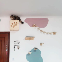 Nicho de madeira para gatos com pegadas, com um gato em cima e prateleiras na parede.