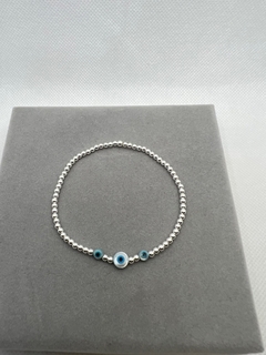 Pulseira silicone bolinhas de prata e olho grego .