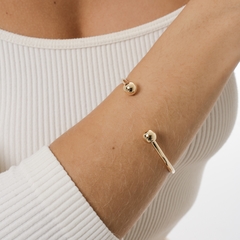 Bracelete liso, com uma esfera pequena também lisa em cada ponta, banhado a Ouro 18k ou Ródio Branco.