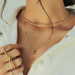 Colar delicado, banhado a Ouro 18k, com pingente liso em formato de inicial.