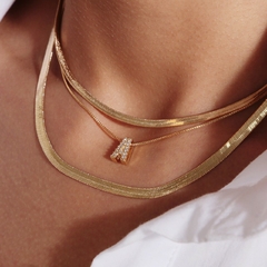 Colar com pingente cravejado em formato de inicial, banhado a Ouro 18k.