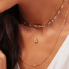 Colar de fio de nylon com pingente cravejado em formato de letra inicial, banhado a Ouro 18k.