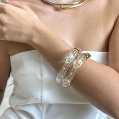Bracelete de acrílico em formato quadrado com cantos abaulados, aro interno e fecho banhados a Ouro 18k. 