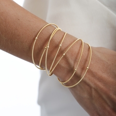 Pulseira corda de violão, composta por fios delicados com pequenas esferas ao longo do comprimento, banhado a Ouro 18k ou Ródio Branco.