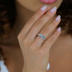 Anel tubo com detalhe cravejado com zircônias, banhado em Ródio Branco.