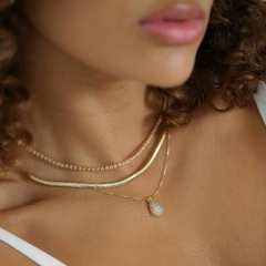 Colar delicado, banhado a Ouro 18k ou Ródio Branco, com pingente em formato de gota, cravejado com zircônias brilhantes.